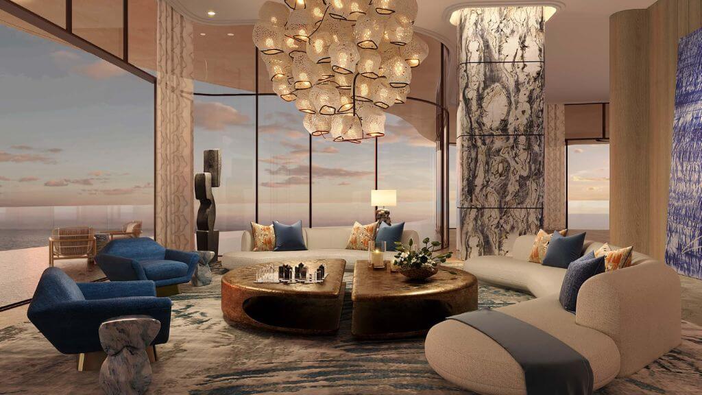Jumeirah Asora Bay Interior Living Room | Ultra-Luxury Beachfront Apartment Interior lounge space at Jumeirah Asora Bay showcasing modern curved seating, custom lighting, marble accents, and panoramic sea views at sunset.